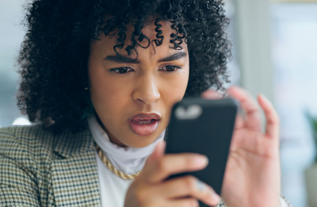 Mujer sorprendida mirando el teléfono celular