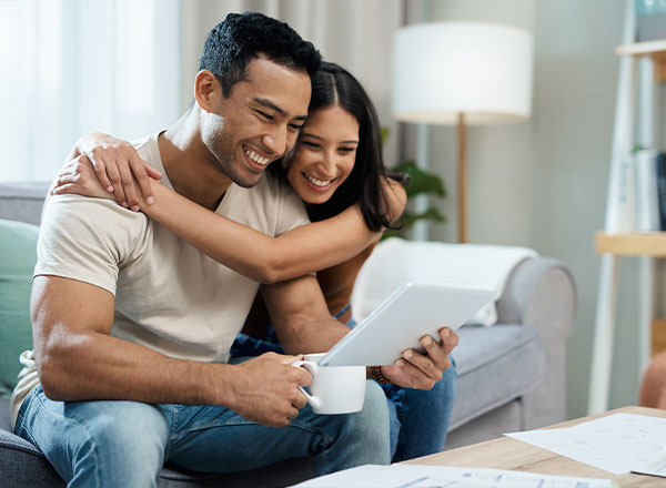 pareja mirando tableta y sonriendo