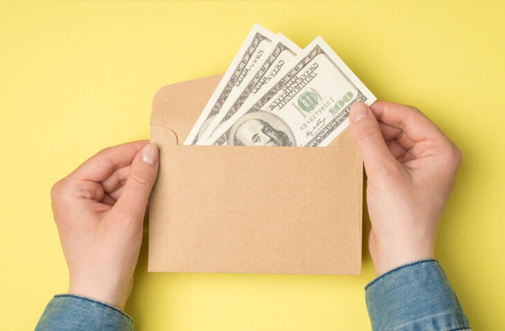 stuffing cash in an envelope